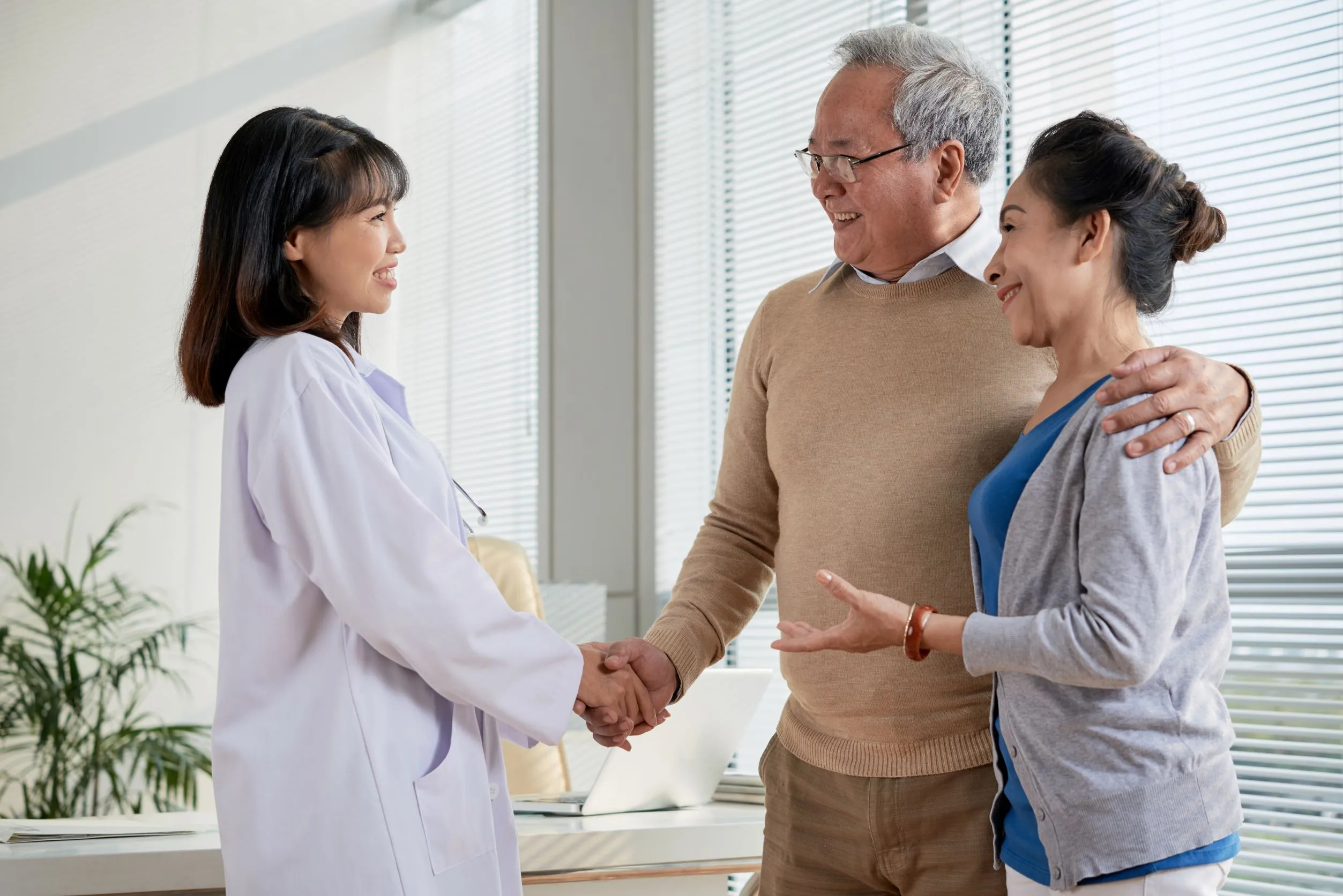 A healthcare professional conversing with an elderly couple